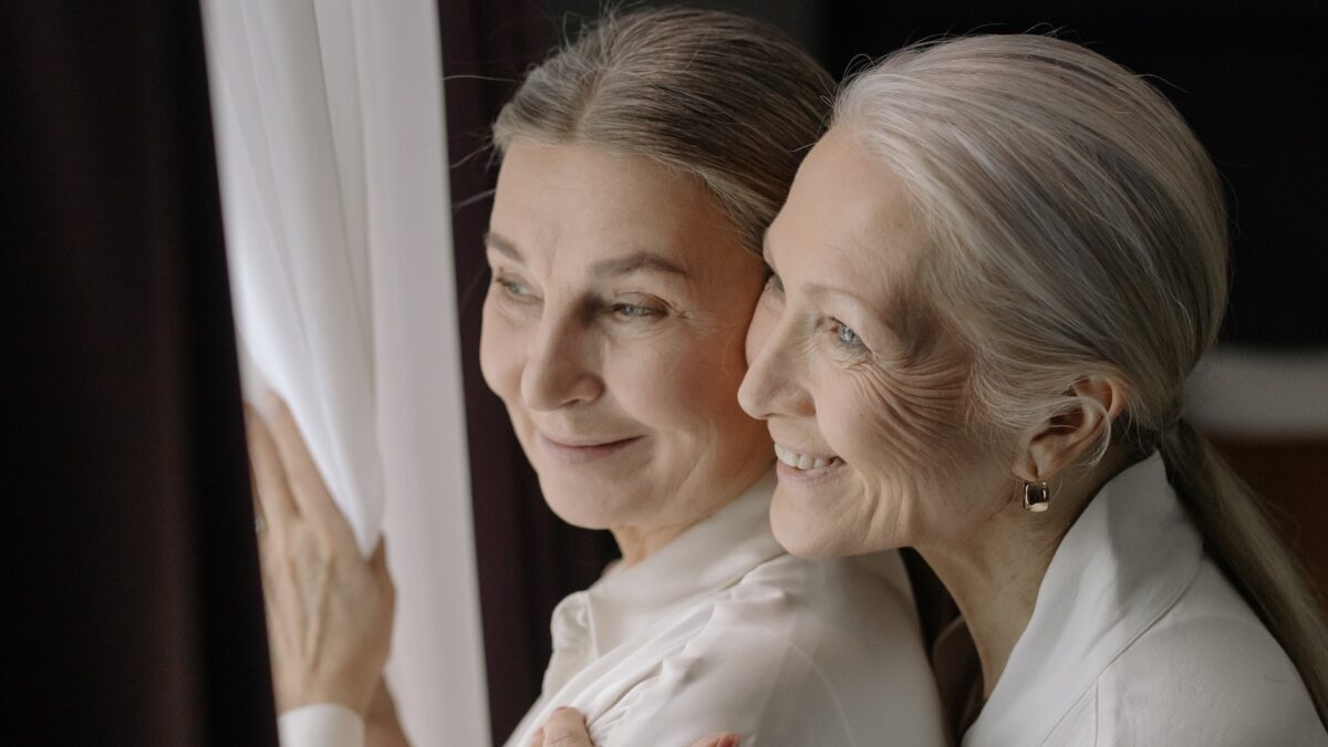 Mother and daughter staring outside window