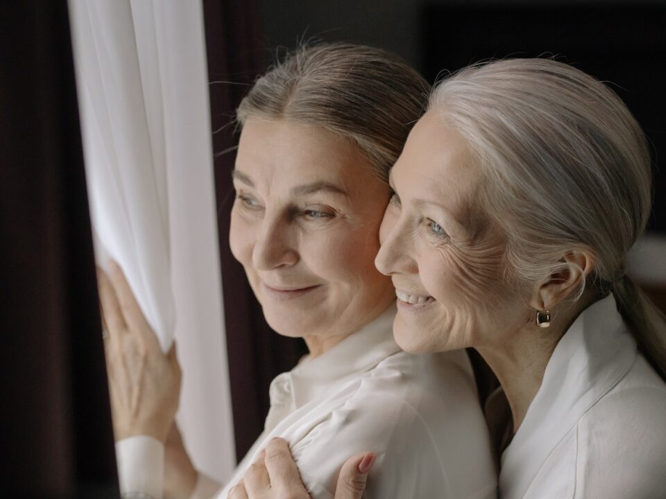 Mother and daughter staring outside window