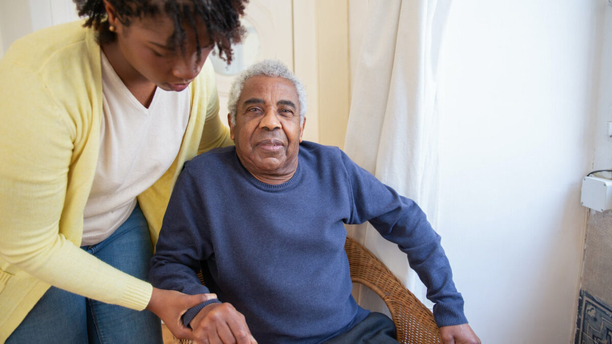 Nurse assisting elderly man