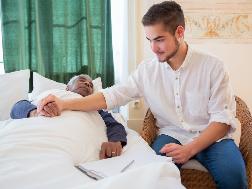 Nurse holding elderly man's hands