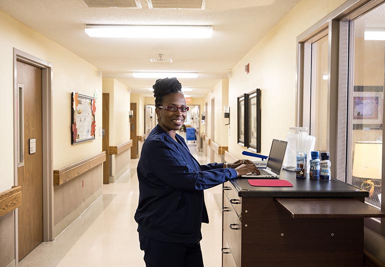 A nurse in uniform standing in a hospital hallway